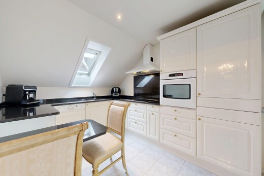 kitchen featuring white appliances, white cabinetry, a skylight, vaulted ceiling, and light tile patterned floors