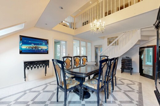 dining area featuring inlaid floor details, hanging lights, and a skylight