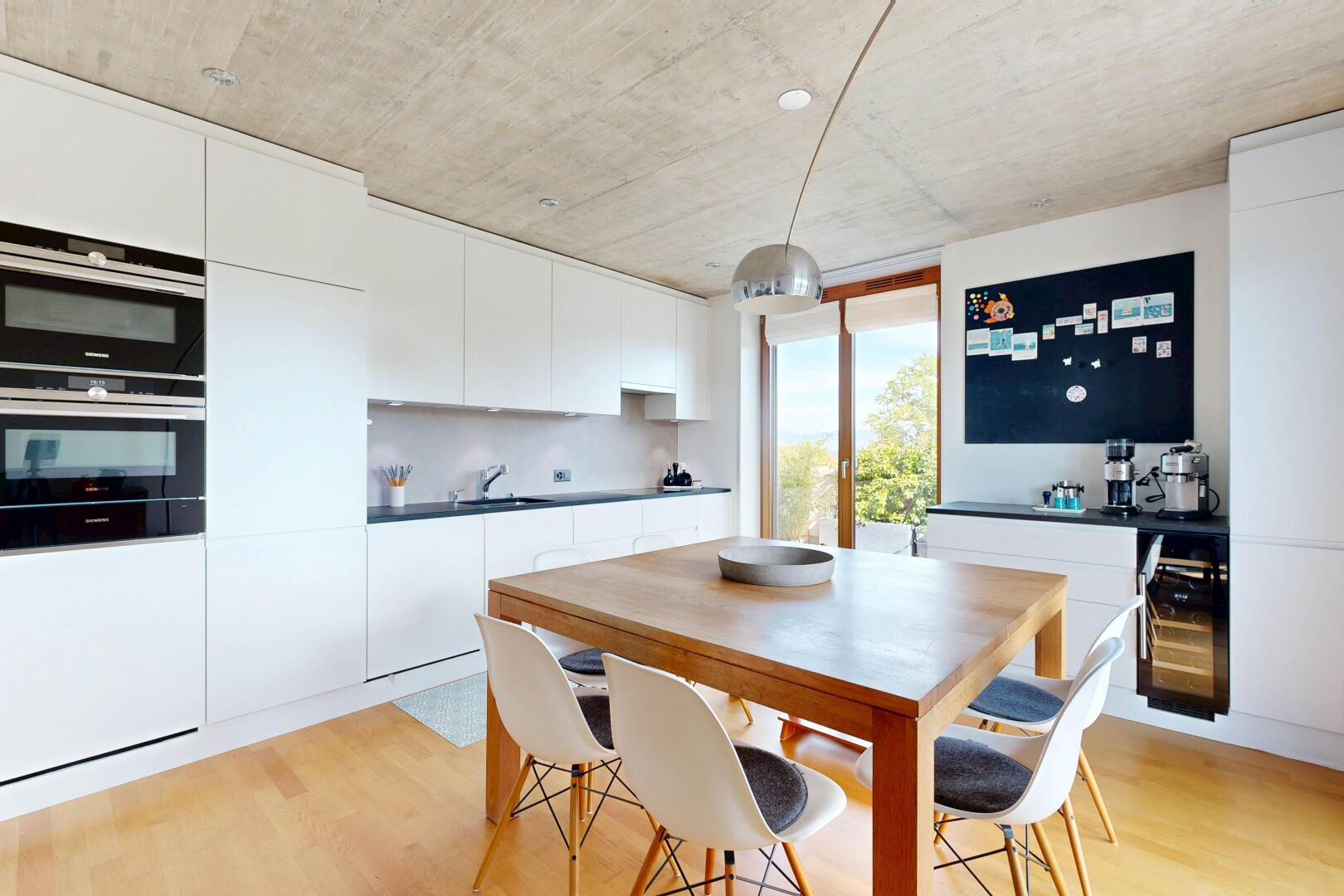 kitchen with double oven, white cabinets, dark countertops, and modern cabinets