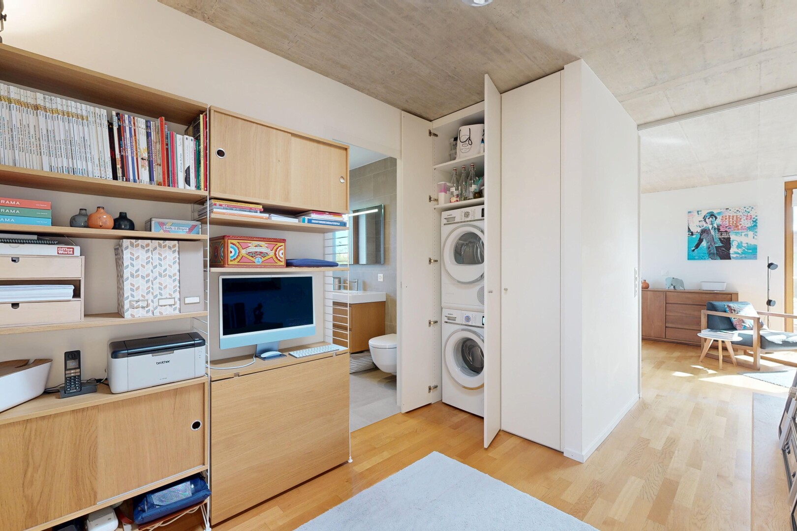 kitchen featuring stacked washer and dryer, light wood-style flooring, and light wood finish cabinets