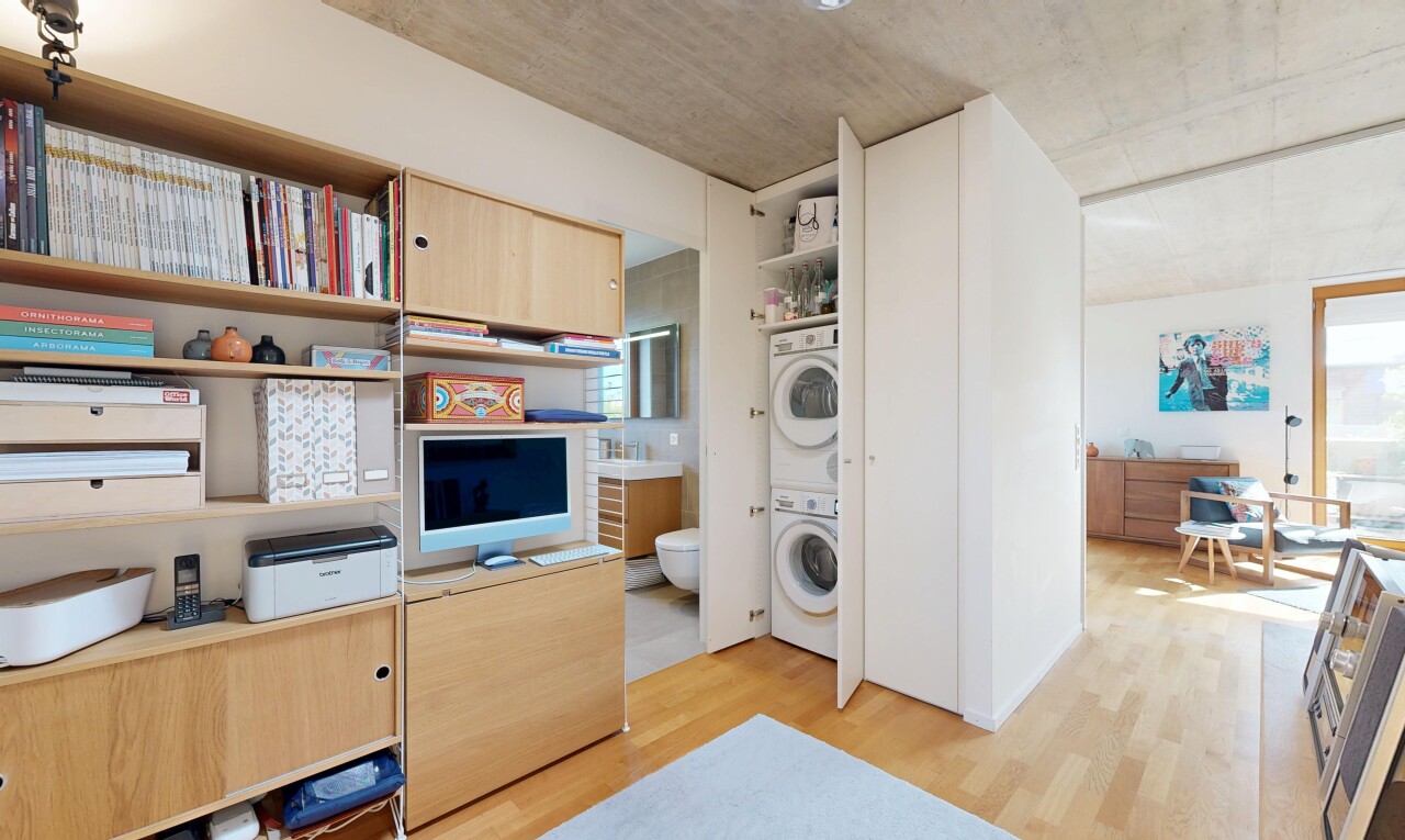 kitchen featuring stacked washer and dryer, light wood-style flooring, and light wood finish cabinets