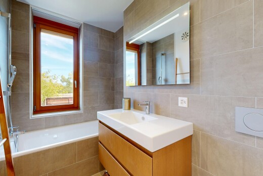 full bathroom featuring vanity, a relaxing tiled tub, tile walls, and a shower