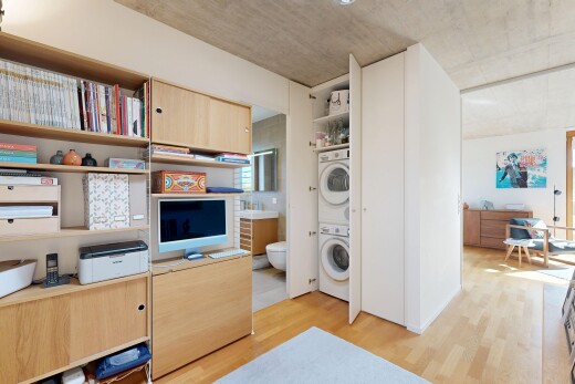 kitchen featuring stacked washer and dryer, light wood-style flooring, and light wood finish cabinets
