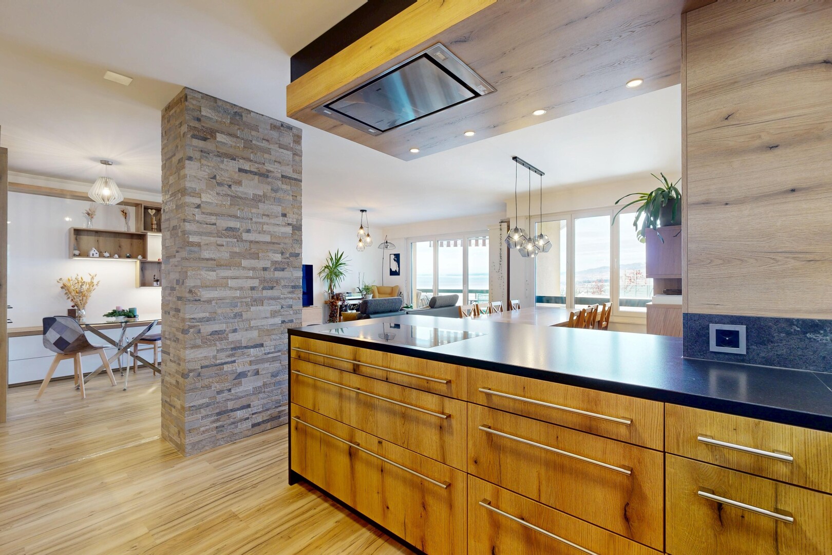 kitchen with decorative light fixtures, brown cabinets, a chandelier, and light wood-type flooring