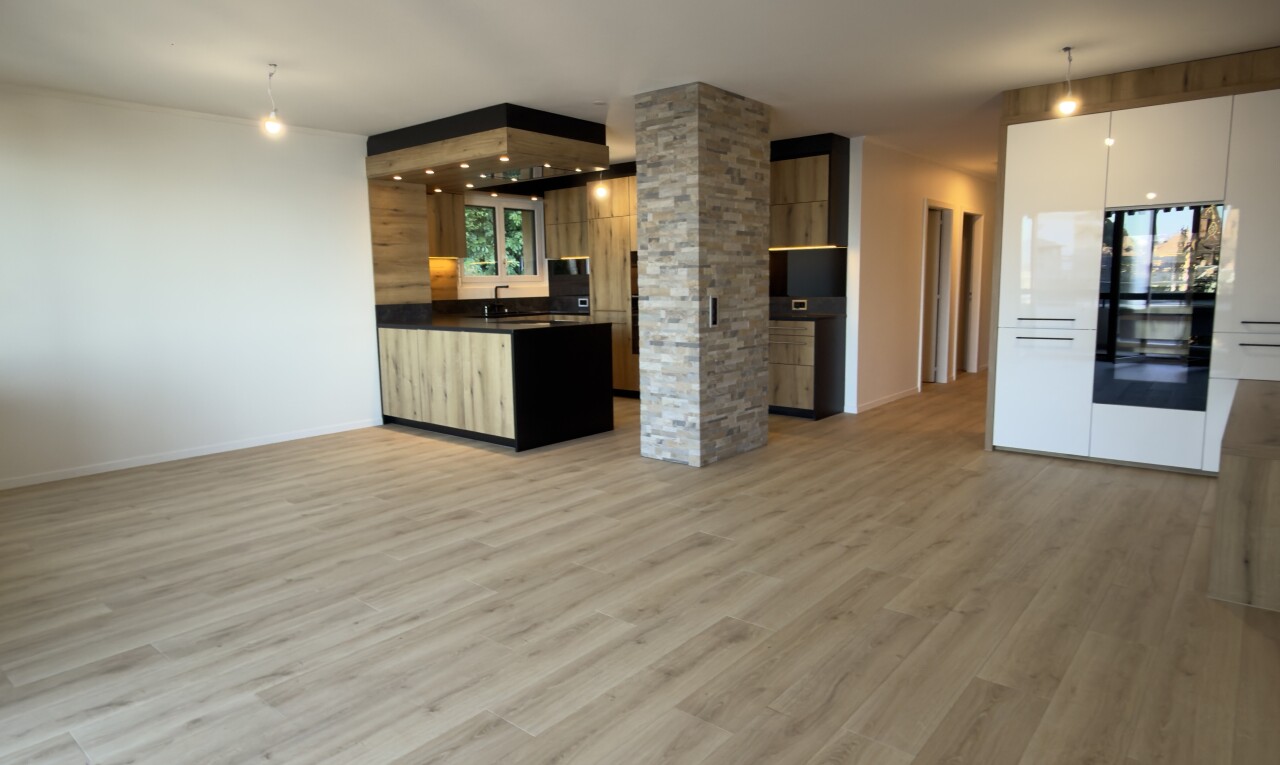 cuisine avec éclairage suspendu, wood finish floor, sol en finition bois, opens to living area, et ouvert sur l'espace de vie