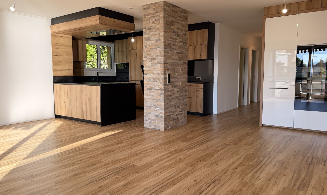 kitchen featuring modern cabinets, light wood finished floors, light wood finish cabinets, dark countertops, and ornate columns