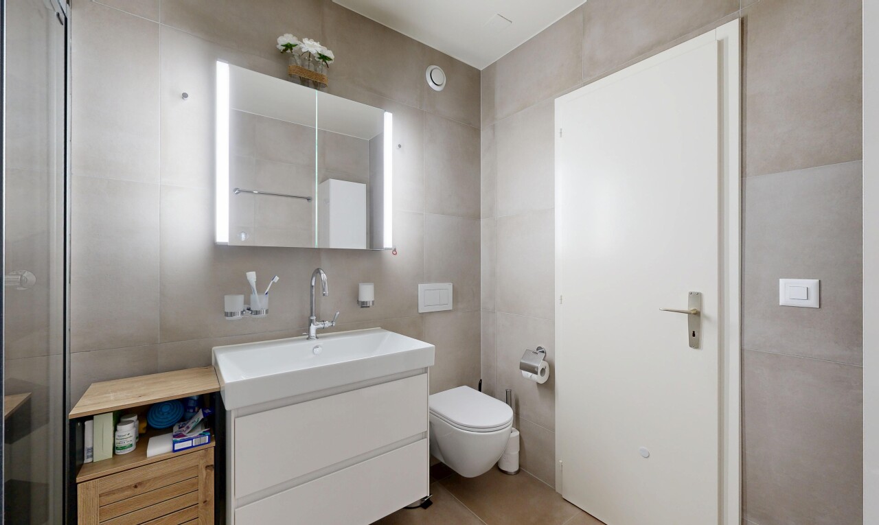 bathroom with vanity and tile walls