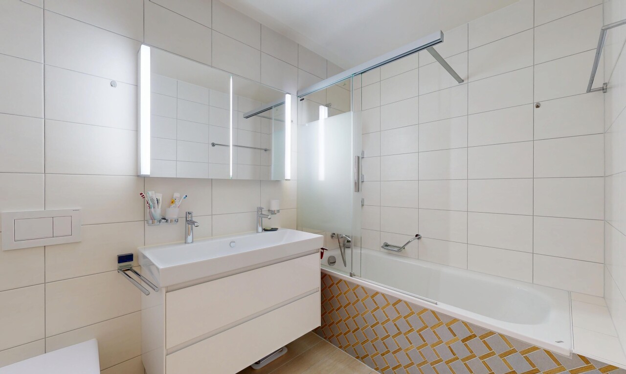 bathroom featuring tile walls, tiled shower / bath combo, and vanity