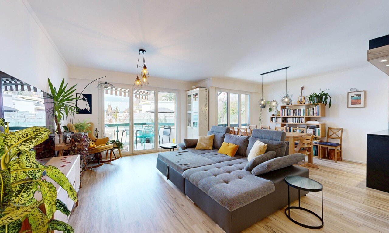 living area with a chandelier, light wood finished floors, and plenty of natural light