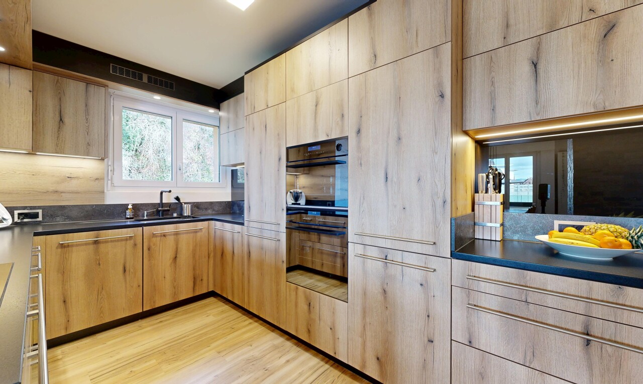 kitchen with dark countertops, light brown cabinetry, light wood finished floors, and modern cabinets