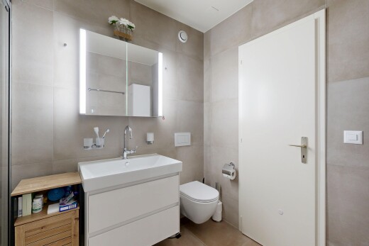salle de bains avec miroir, lavabo (ou coiffeuse selon le contexte), mur en carrelage, tile wall, et inside property
