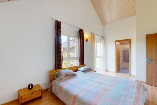 chambre avec plafond haut, high ceiling, inside property, sol en finition bois, et wood finish floor