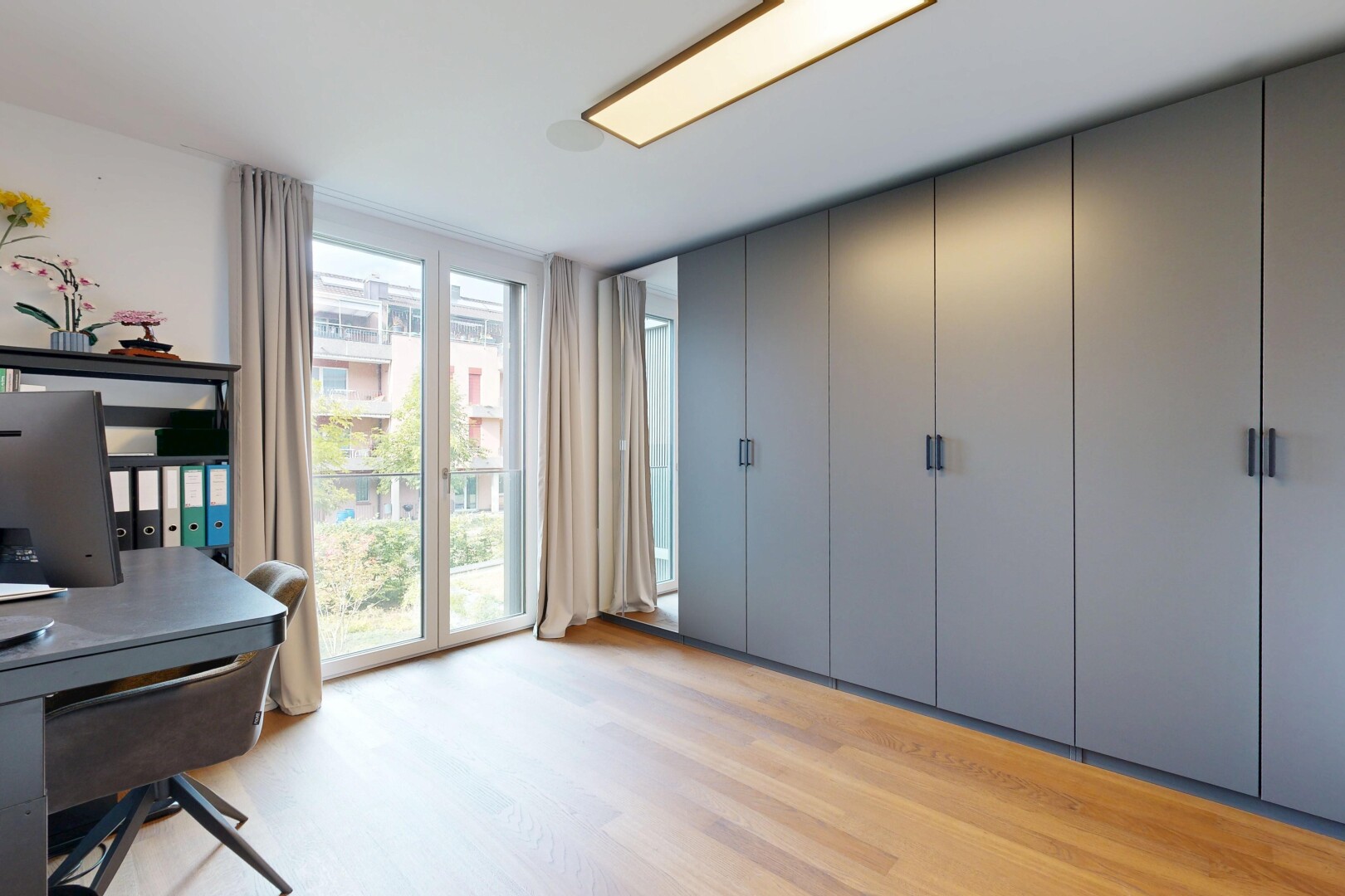büro mit wood finish floor, holzfußboden, fernseher, light floor, und inside property