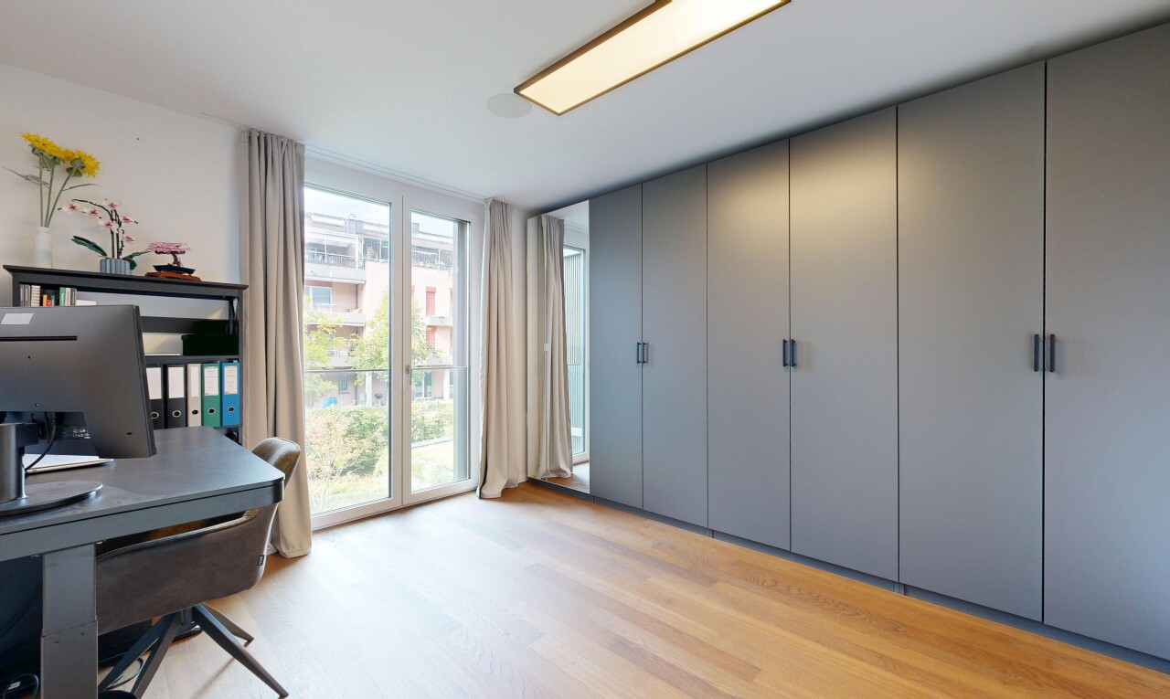 büro mit wood finish floor, holzfußboden, fernseher, light floor, und inside property