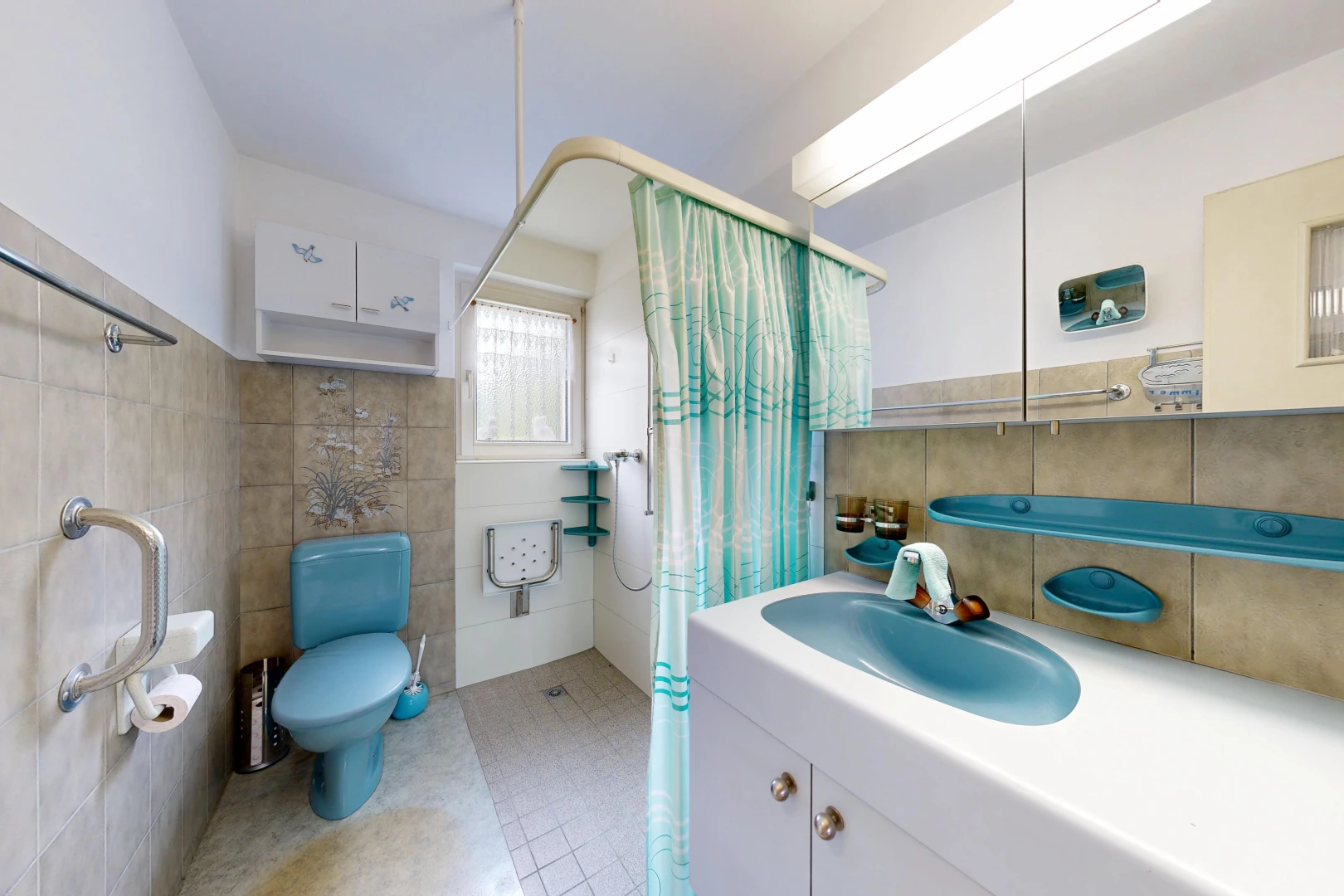 full bath with a shower with curtain, tile walls, vanity, and light tile patterned floors