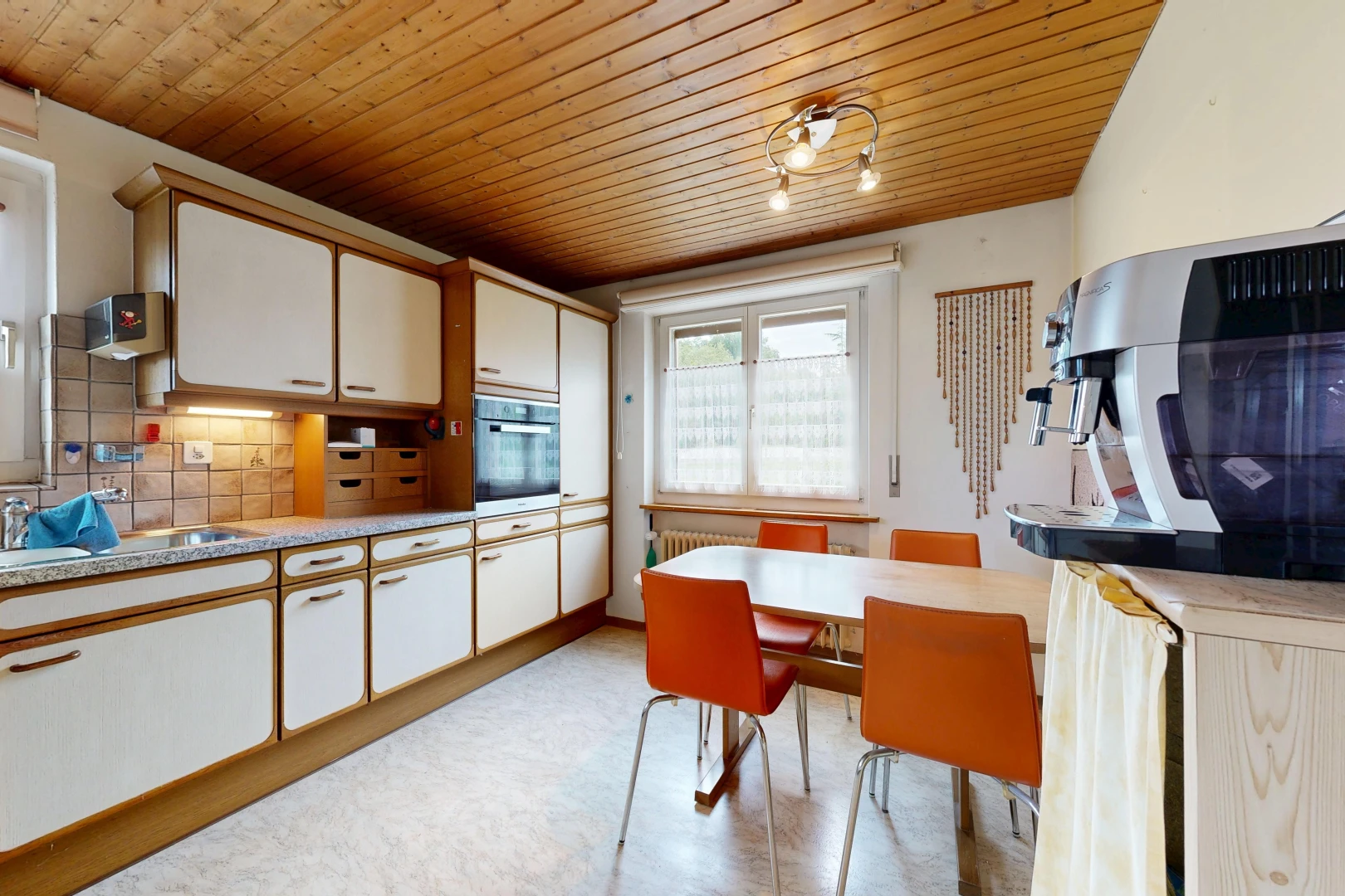 kitchen featuring wooden ceiling, light countertops, two tone color scheme, tasteful backsplash, and oven
