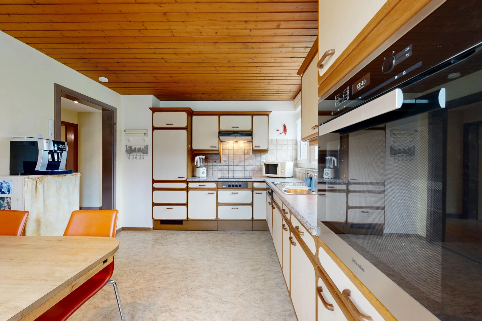 dual tone kitchen featuring oven, wooden ceiling, dual tone cabinetry, tasteful backsplash, and light countertops