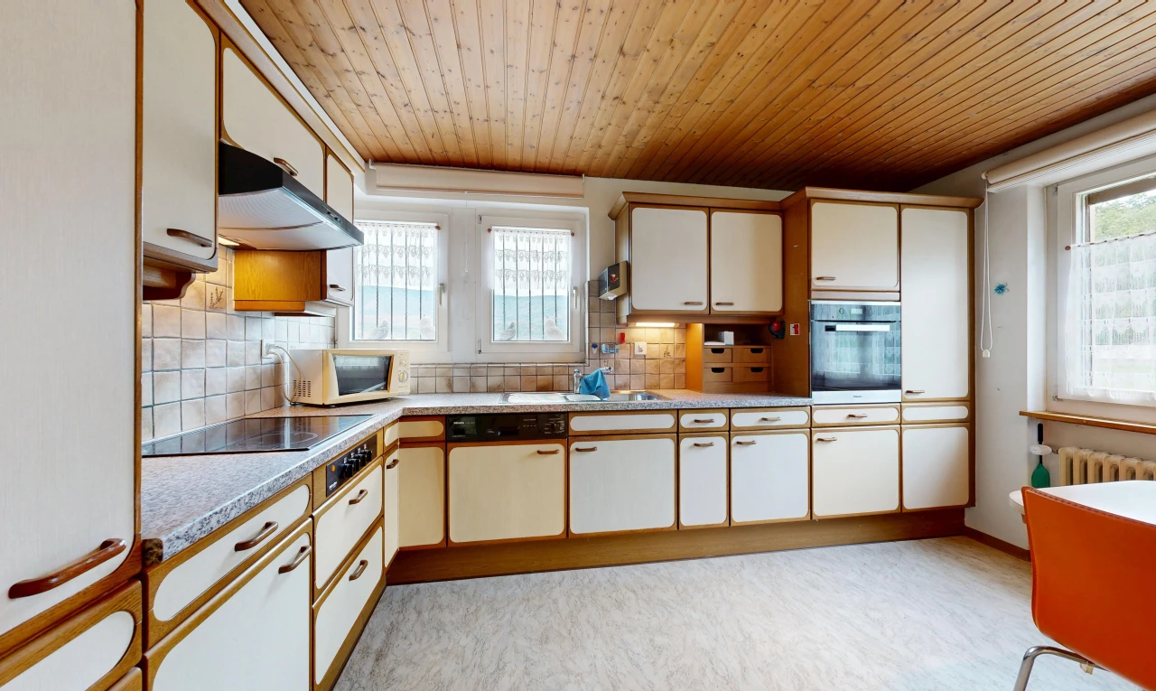 kitchen featuring light countertops, two tone cabinets, oven, wooden ceiling, and white microwave
