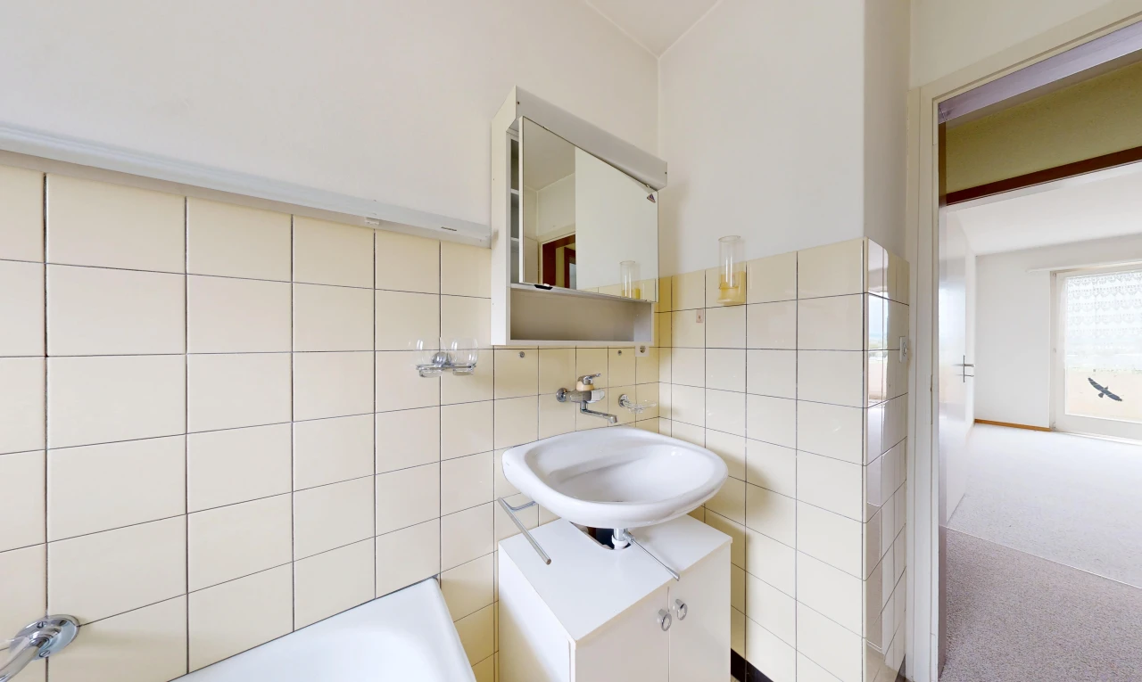 full bath with tile walls and a bathtub