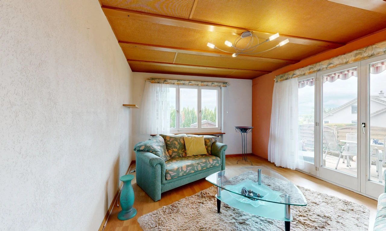 living room with access to outside, light wood-type flooring, and a textured wall