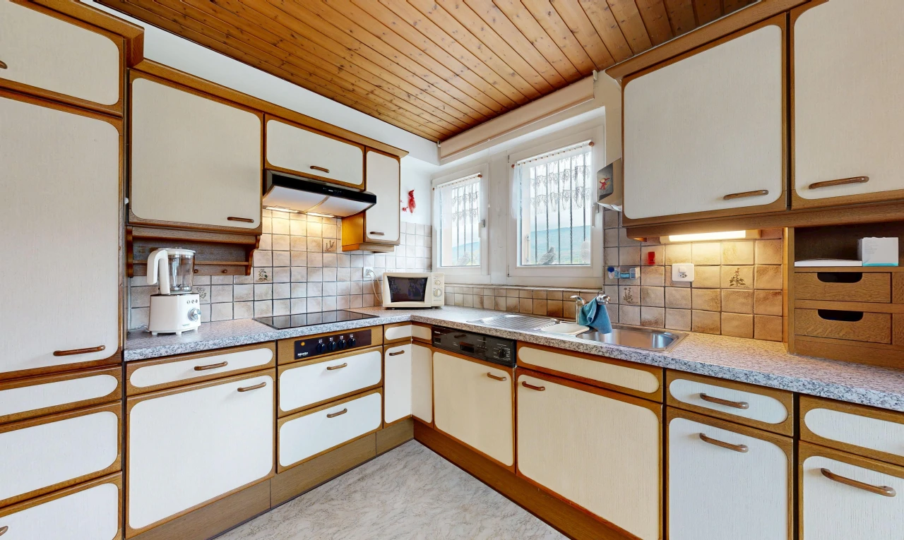 dual tone kitchen with light countertops, wooden ceiling, two tone color scheme, decorative backsplash, and white appliances