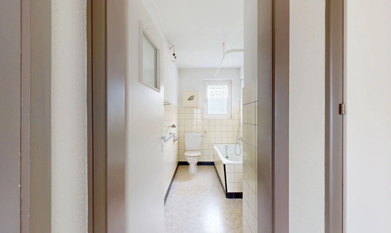 bathroom featuring a garden tub, tile walls, and wainscoting