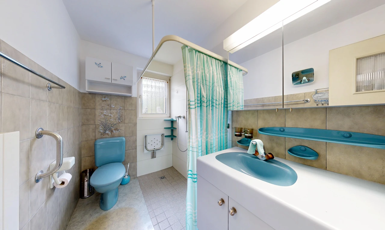 full bath with a shower with curtain, tile walls, vanity, and light tile patterned floors