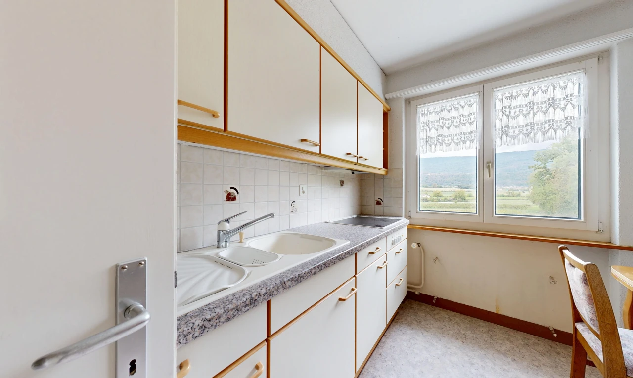 two tone kitchen with light countertops, dual tone cabinetry, and backsplash