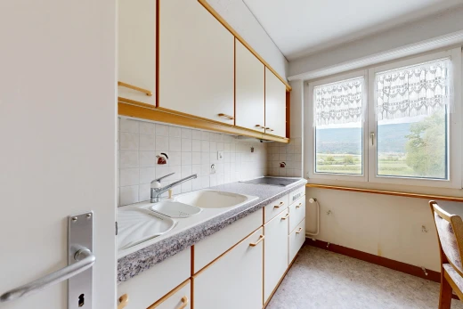 two tone kitchen with light countertops, dual tone cabinetry, and backsplash