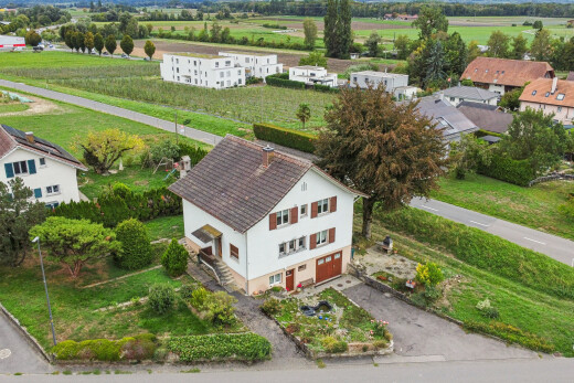 view of home with an attached garage, driveway, and a rural view