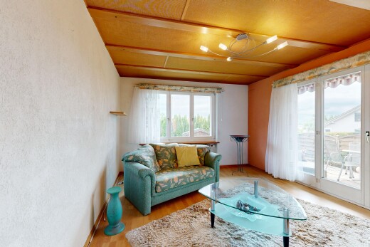 living room with access to outside, light wood-type flooring, and a textured wall