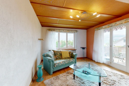 living room with access to outside, light wood-type flooring, and a textured wall