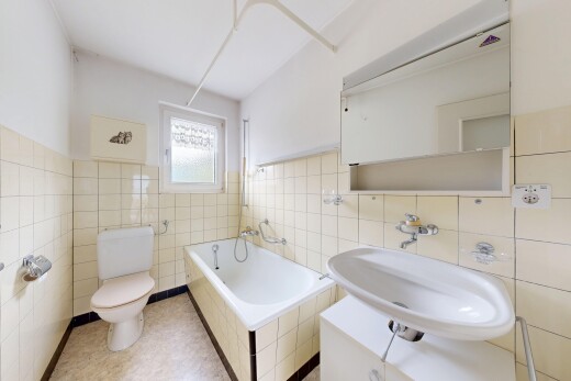 bathroom featuring a relaxing tiled tub, tile walls, and wainscoting