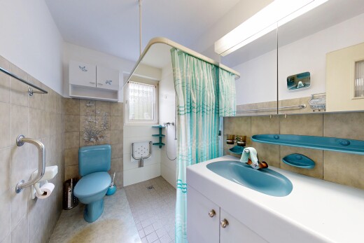 full bath with a shower with curtain, tile walls, vanity, and light tile patterned floors