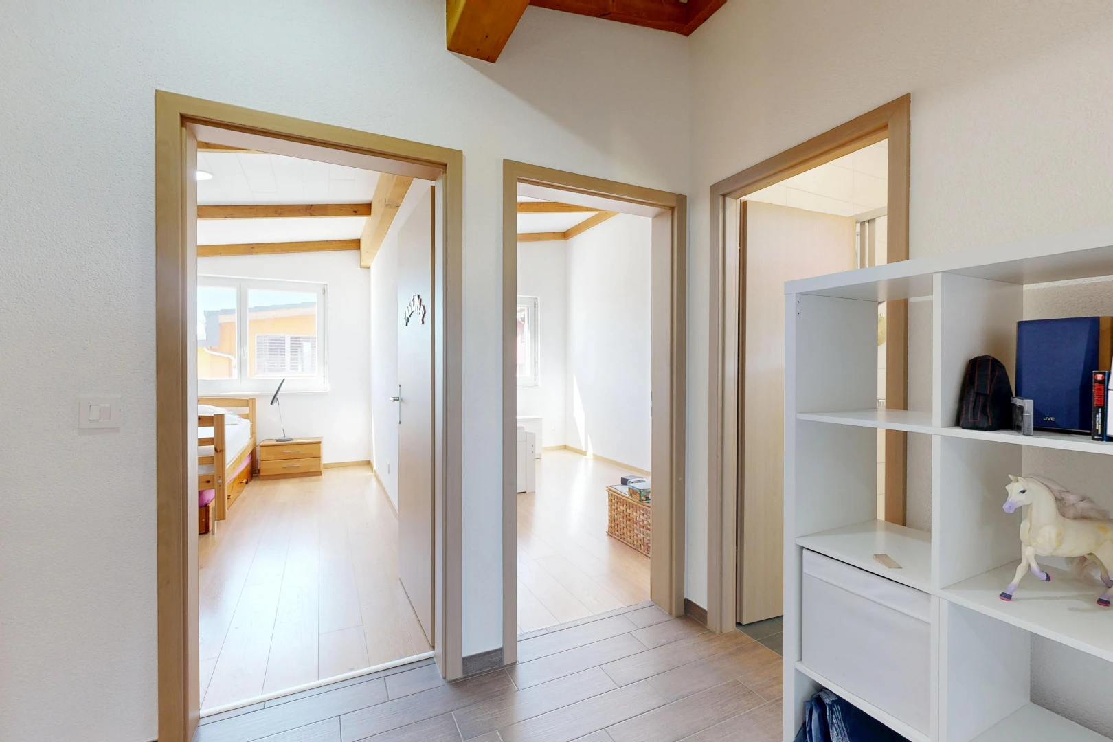 couloir avec cloison sèche, drywall, inside property, sol en finition bois, et wood finish floor