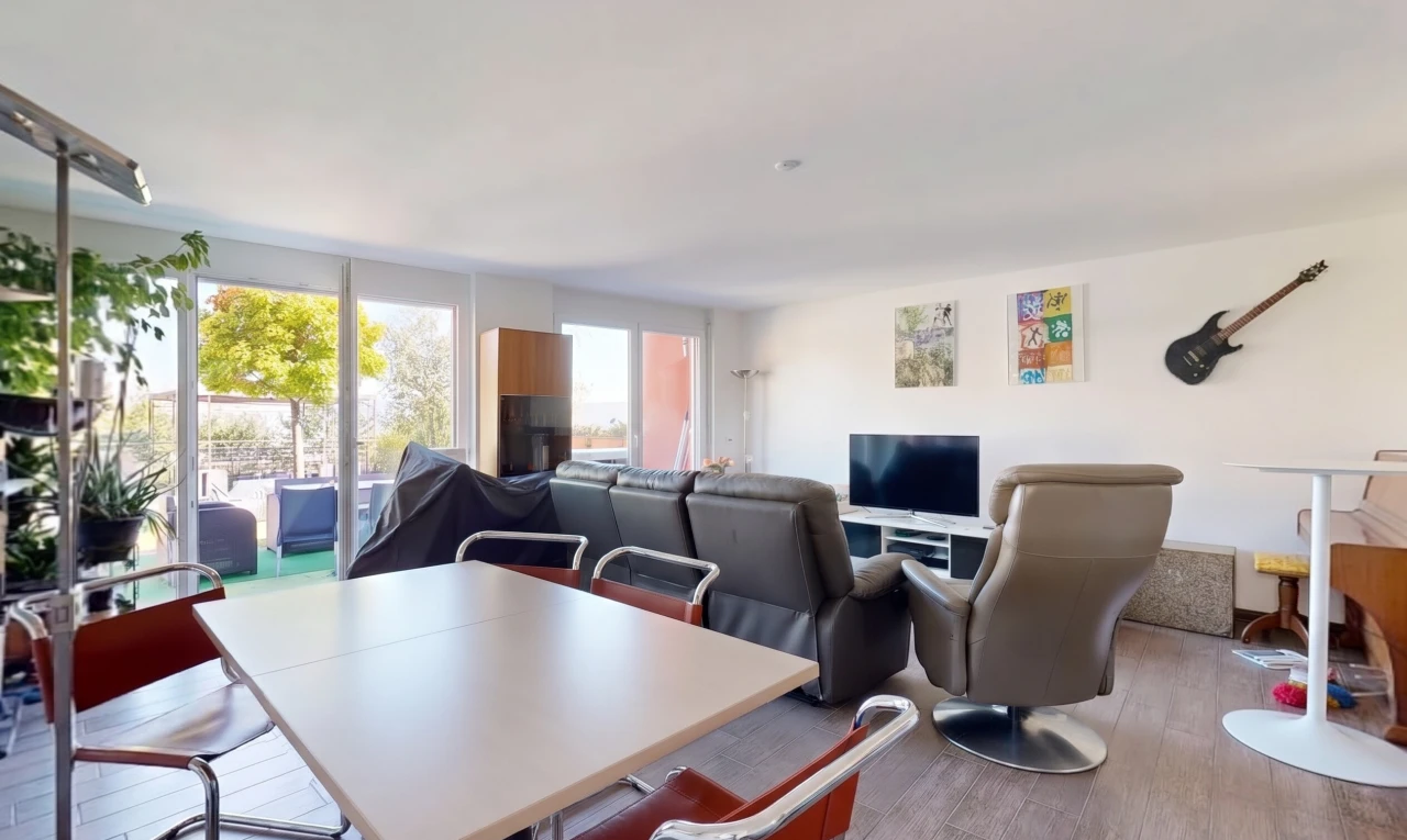 salon / salle à manger avec télévision, accès à l'extérieur, cloison sèche, drywall, et sol en finition bois