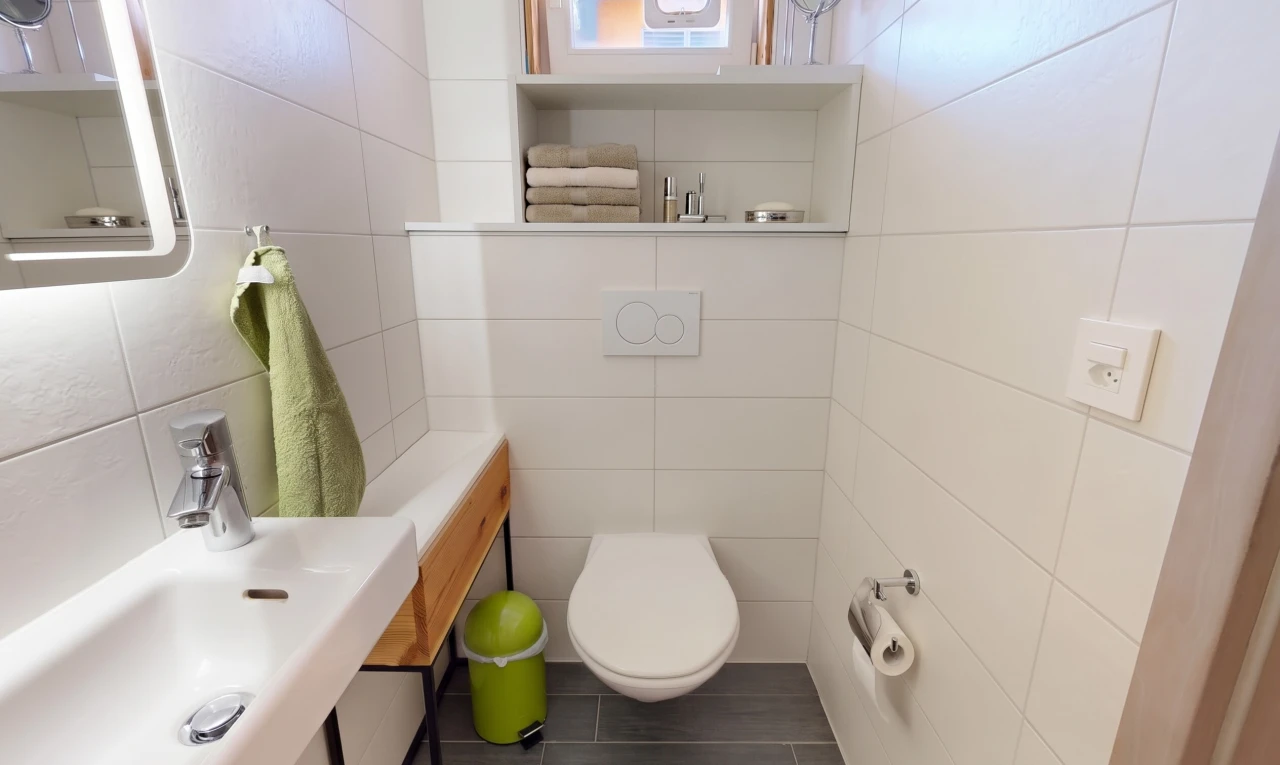 salle de bains avec évier, toilette, miroir, tile wall, et mur en carrelage