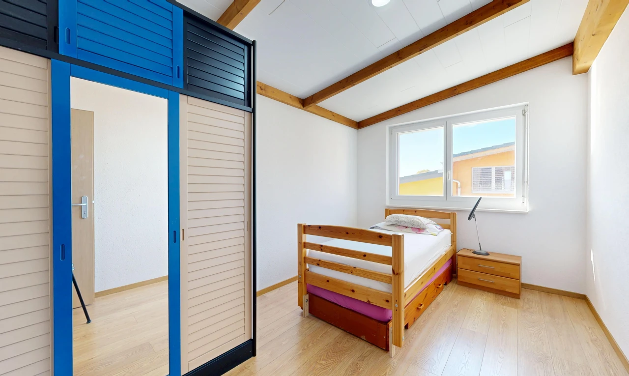 chambre avec beamed ceiling, plafond à poutres, wood finish floor, sol en finition bois, et placard