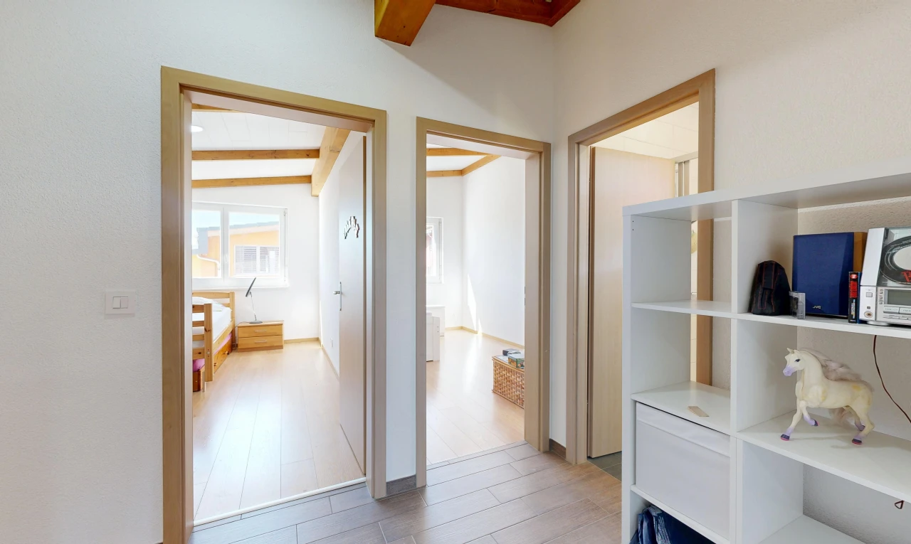 couloir avec cloison sèche, drywall, inside property, sol en finition bois, et wood finish floor