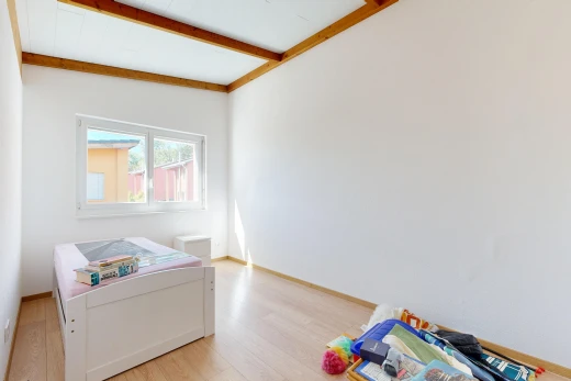 chambre avec beamed ceiling, plafond à poutres, drywall, cloison sèche, et wood finish floor