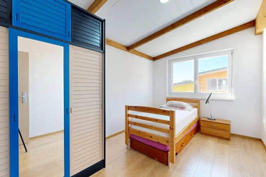chambre avec beamed ceiling, plafond à poutres, wood finish floor, sol en finition bois, et placard