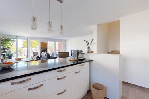 cuisine avec white cabinets, armoires blanches, éclairage suspendu, dark countertops, et plans de travail