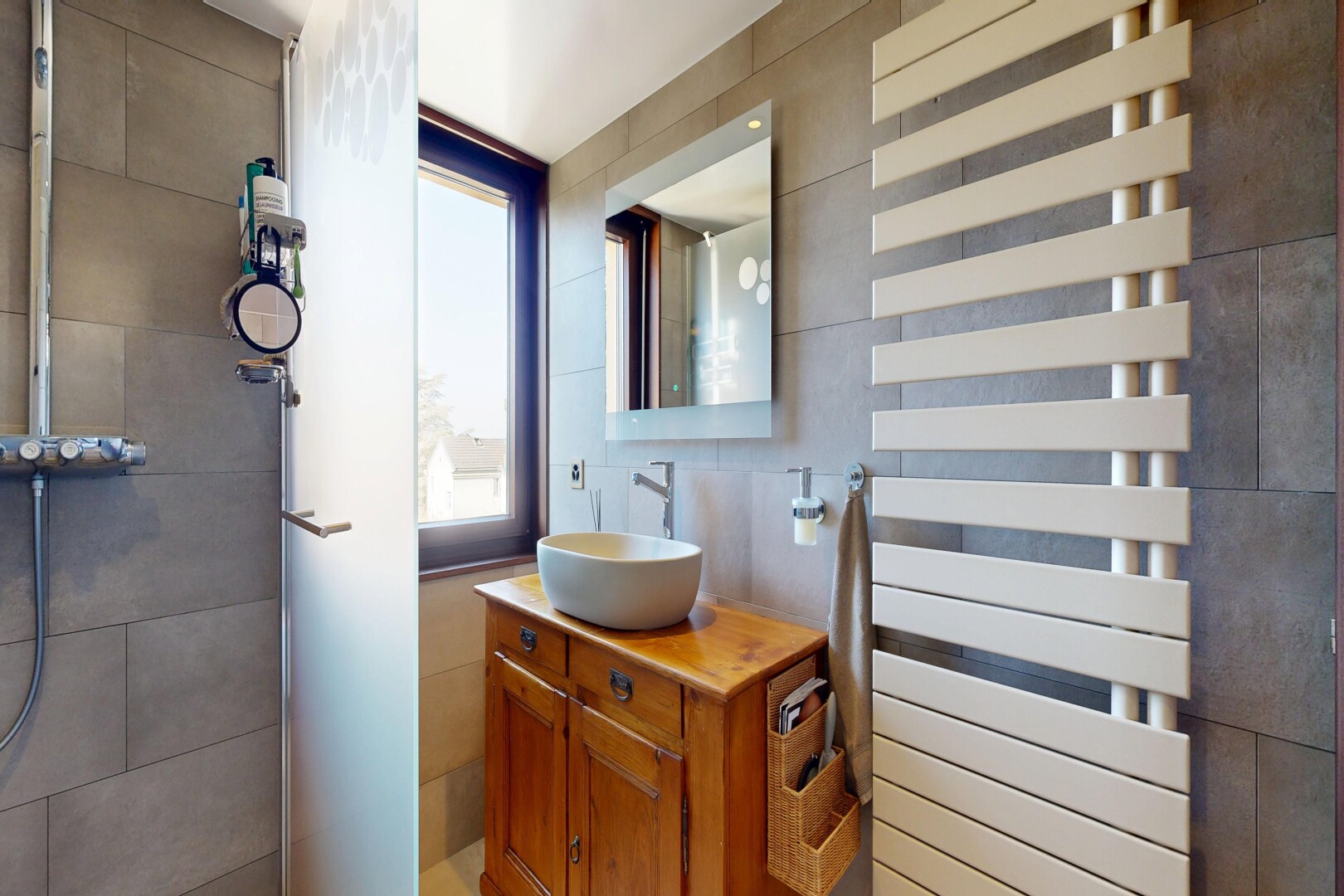 salle de bains avec lavabo (ou coiffeuse selon le contexte), miroir, radiateur, chauffe-serviettes, et évier