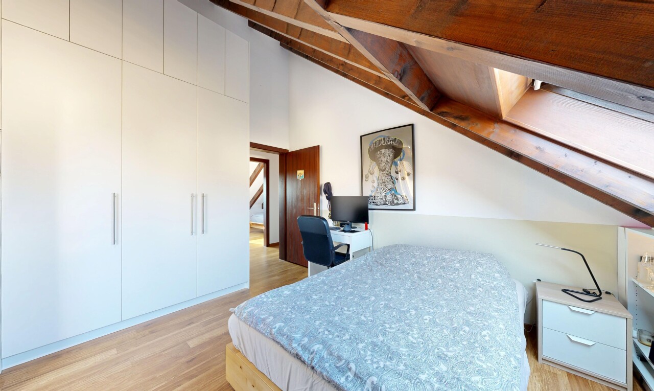 chambre avec sol en finition bois, wood finish floor, inside property, light floor, et télévision