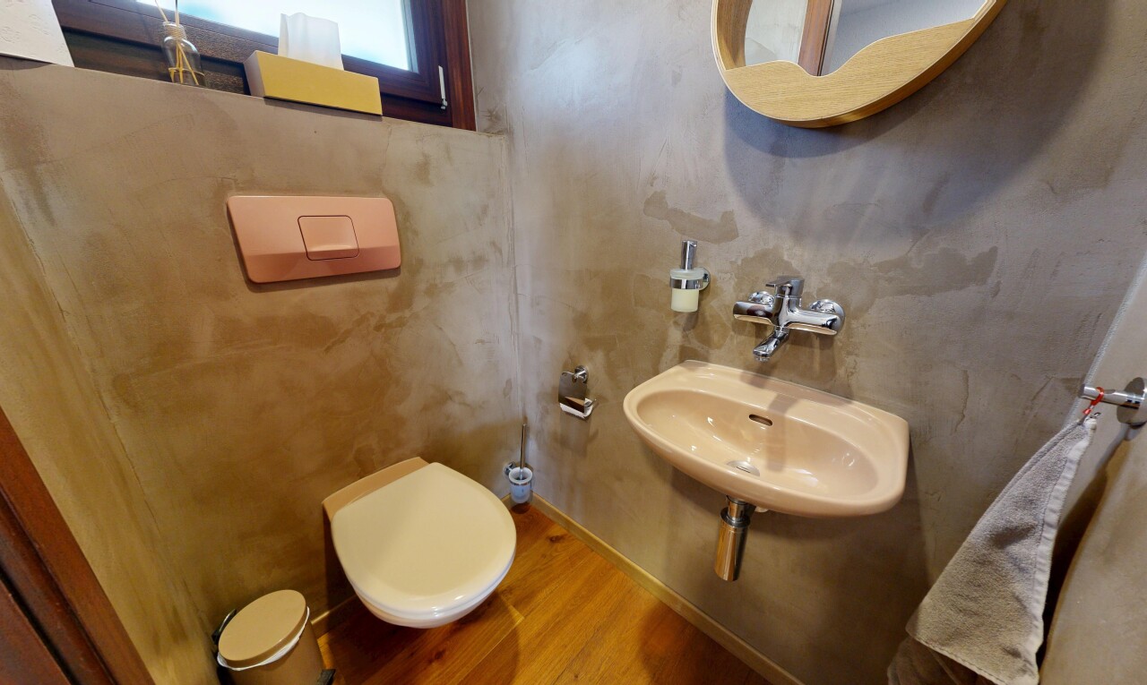 salle de bains avec inside property, miroir, toilette, évier, et wood finish floor