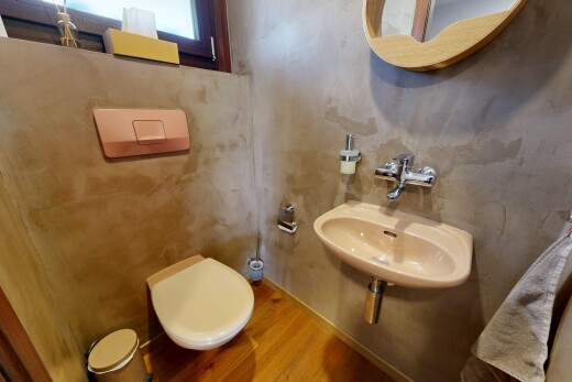 salle de bains avec inside property, miroir, toilette, évier, et wood finish floor