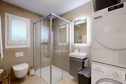salle de bains avec mur en carrelage, tile wall, lavabo (ou coiffeuse selon le contexte), miroir, et salle de bain complète