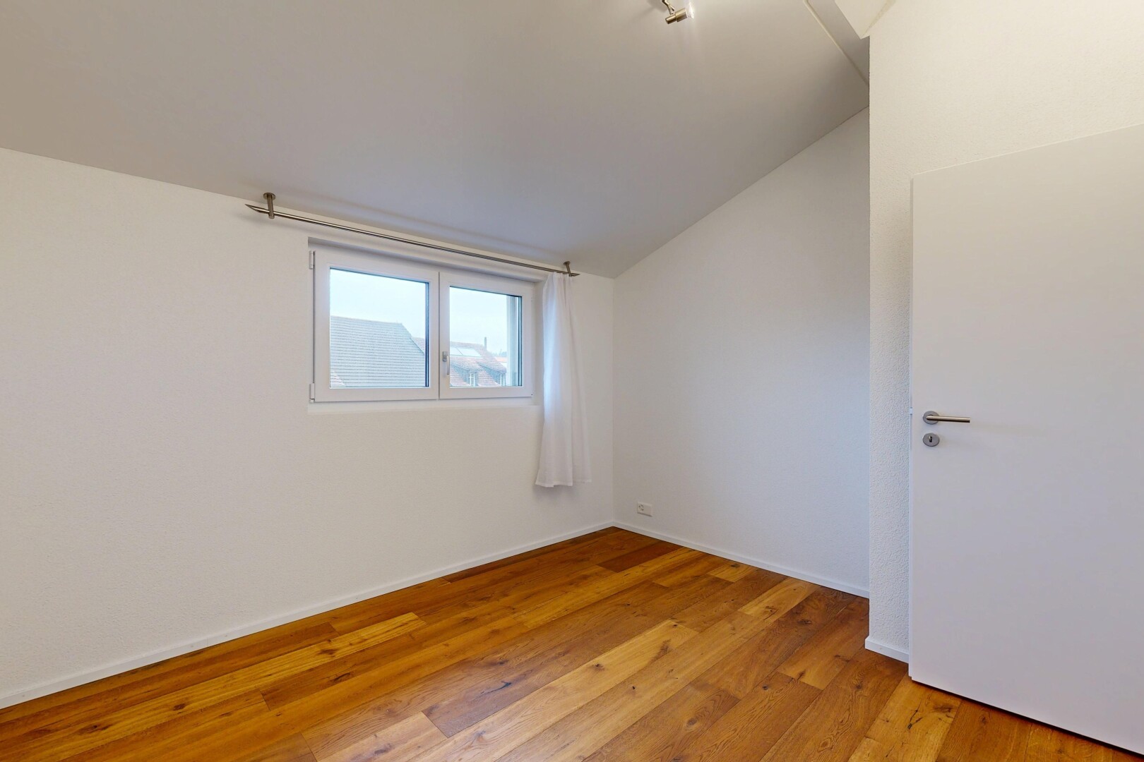pièce vide avec vaulted ceiling, plafond voûté, wood finish floor, sol en finition bois, et inside property