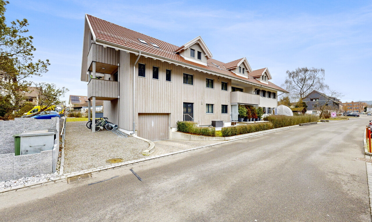 façade avec toit mansardé, bardage vertical, garage intégré, day time, et toit en tuiles