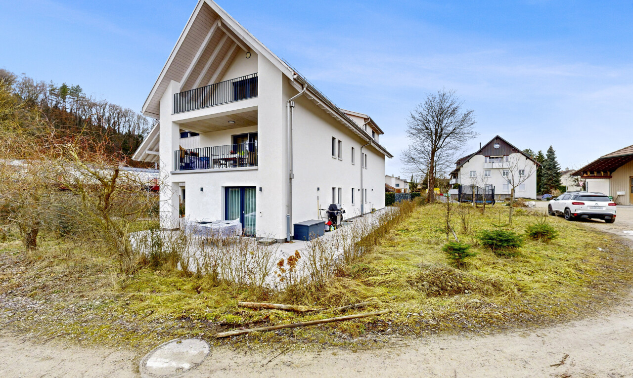 façade avec day time, balcon, bardage en stuc, terrain vierge, et property visible